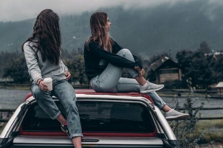 Fashion Journey - Two Women Sitting on Vehicle Roofs