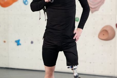 Fashion Influence - Man in Black Long Sleeve Shirt and Black Shorts Standing With Prosthetic Leg